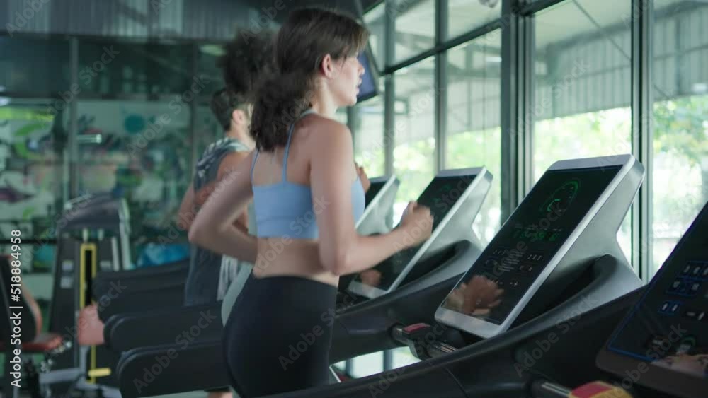 Side view of Fitness girl running, jogging with cardio training on track treadmill. Black woman with muscular bodycare in exercise gym sport club. Fitness, exercising and healthy lifestyle Concept.