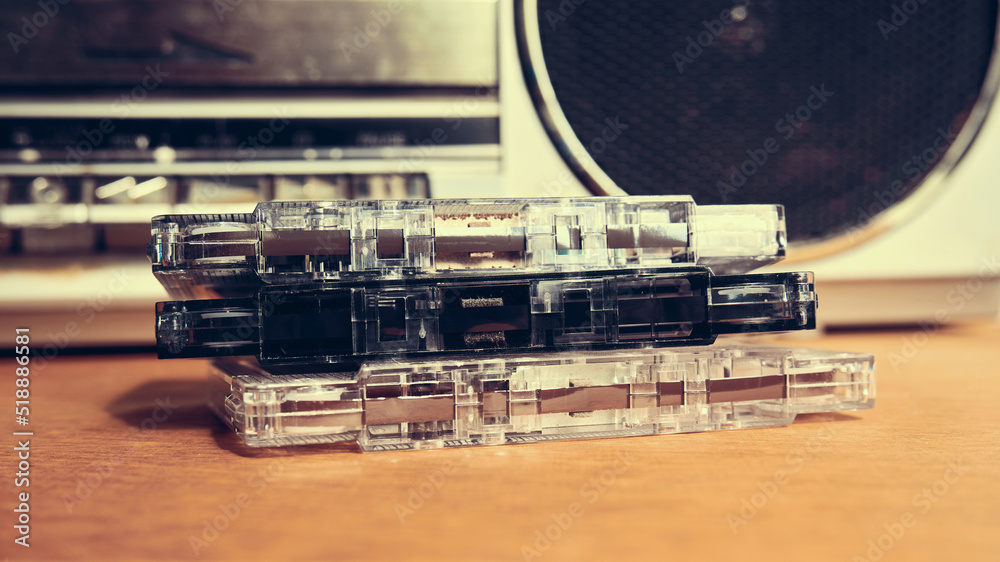 Obraz premium Old audio cassettes on the table close-up. Vintage compact cassettes on the background of a tape recorder