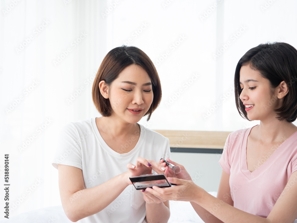 Asian pretty two woman choose color palette together while wearing t-shirt casual style on her bed in white bedroom at apartment