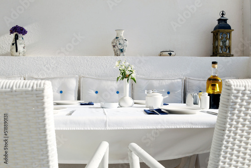 White cushion and white table cloth. The restaurant table is ready for a summer dinner