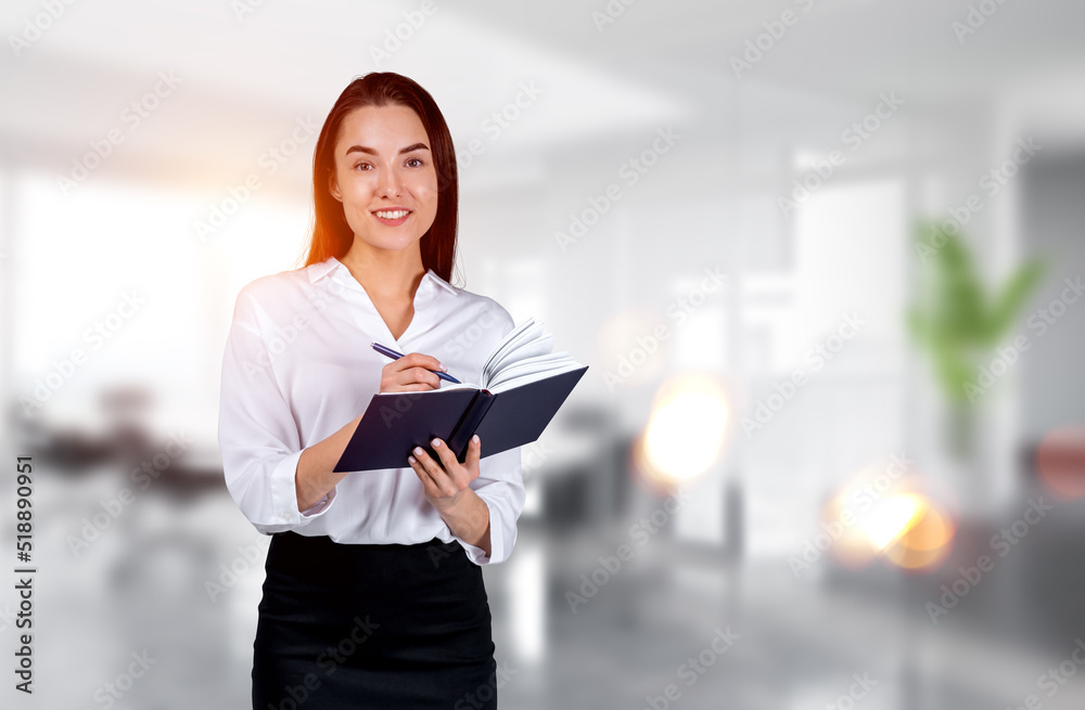 Businesswoman take note in notebook on office background Businesswoman take note in notebook on office background