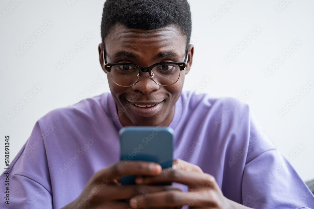 Emotional young african man with smartphone in hand, closeup portrait Emotional young african man with smartphone in hand, closeup portrait