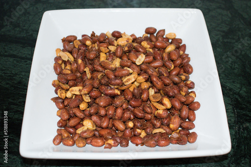 Roasted peanut or moong Fali. Masala peanuts in white bowl or plate.  photo