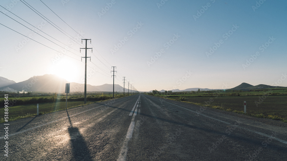 An empty road with lampposts on the side An empty road with lampposts on the side