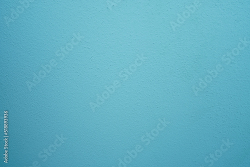 abstract, rough plaster wall texture is light blue for backgroun