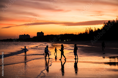 Silhouette family enjoy on Cha Am beach at sunset, Thailand