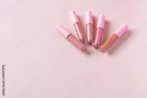 Group of different shades liquid lipsticks on the pink background.
