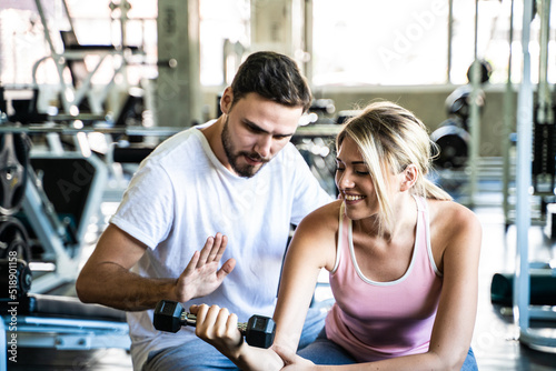 Fototapeta Naklejka Na Ścianę i Meble -  Smart sport man and woman working out in fitness gym