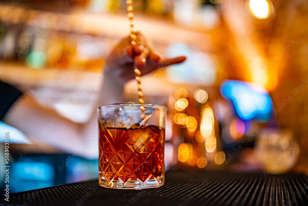 woman bartender hand making negroni cocktail. Negroni classic cocktail and gin short drink with sweet vermouth, red bitter liqueur woman bartender hand making negroni cocktail. Negroni classic cocktail and gin short drink with sweet vermouth, red bitter liqueur