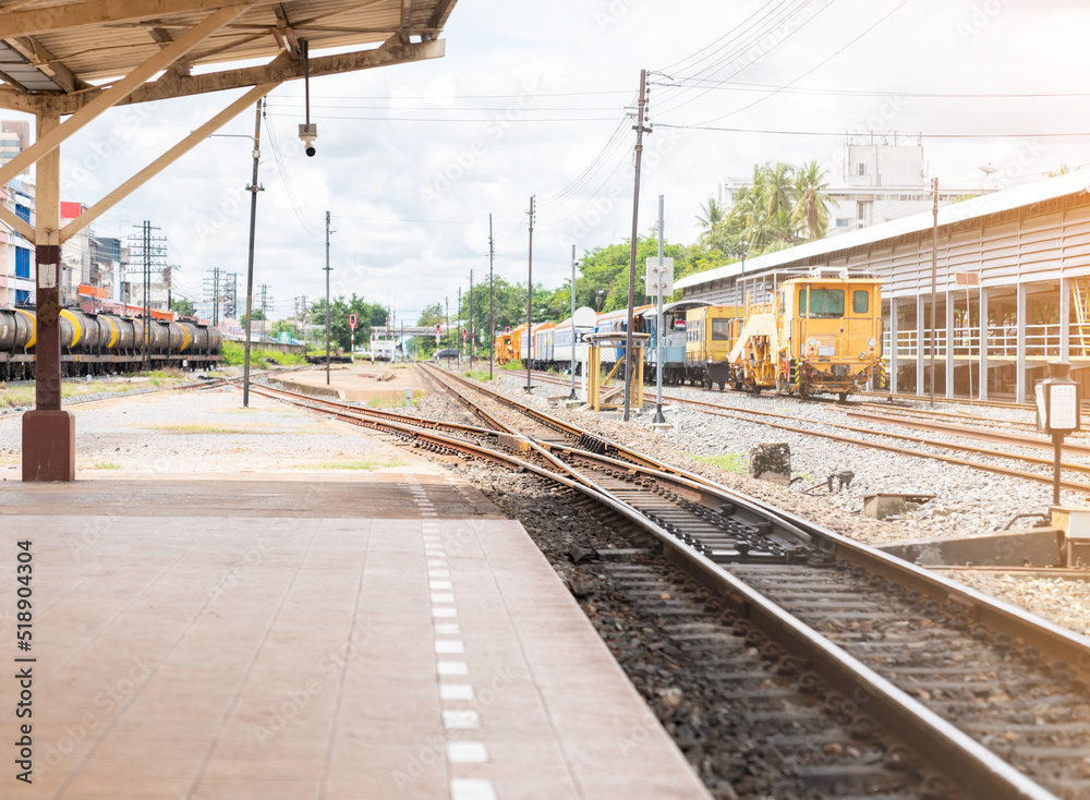 Fototapeta premium Two railway tracks merge together to station platform.