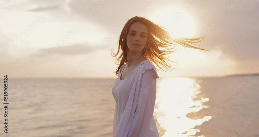 Silhouette of young woman looks at the sea sunset from a hill, slow motion Silhouette of young woman looks at the sea sunset from a hill, slow motion