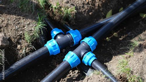 Connecting HDPE plastic water pipes in garden closeup photo