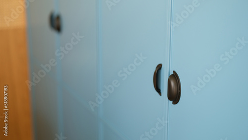 Blue sliding wardrobe with stylish reliable black handles for opening and closing