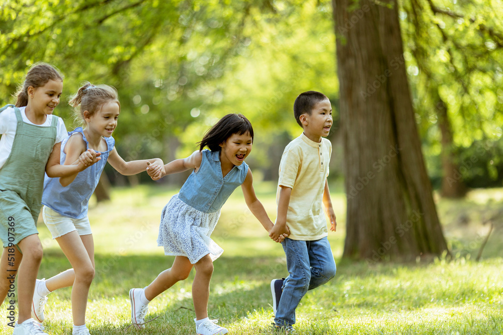 Fototapeta premium Group of asian and caucasian kids having fun in the park