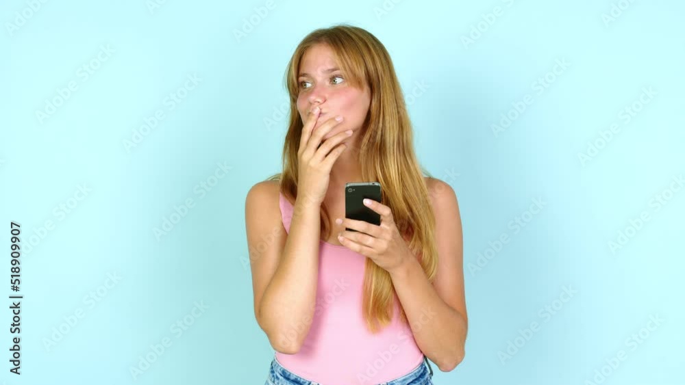 Young pretty blonde woman using mobile phone and thinking over isolated background Young pretty blonde woman using mobile phone and thinking over isolated background