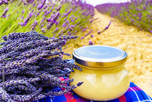 Jar with honey and lavender flowers.