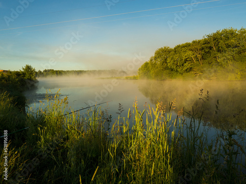 Sunrise over a foggy lake. early morning on the river. sunrise and mist over water and trees with reflections on the river bank.