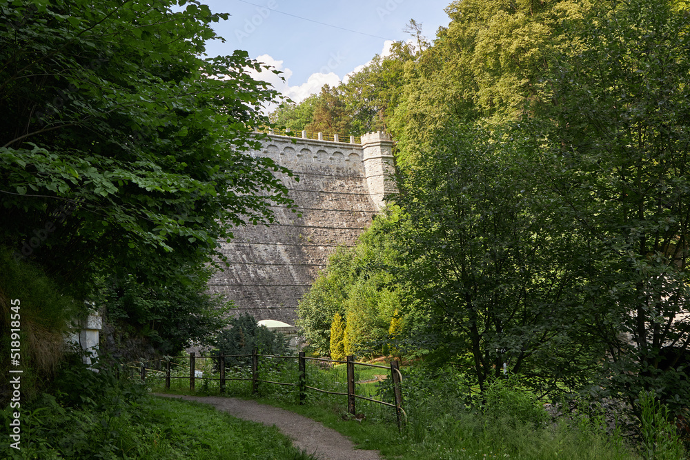 Large old stone dam against the blue sky, in Poland.