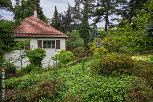 House with red tiles in an ornamental garden. Botanical Garden.