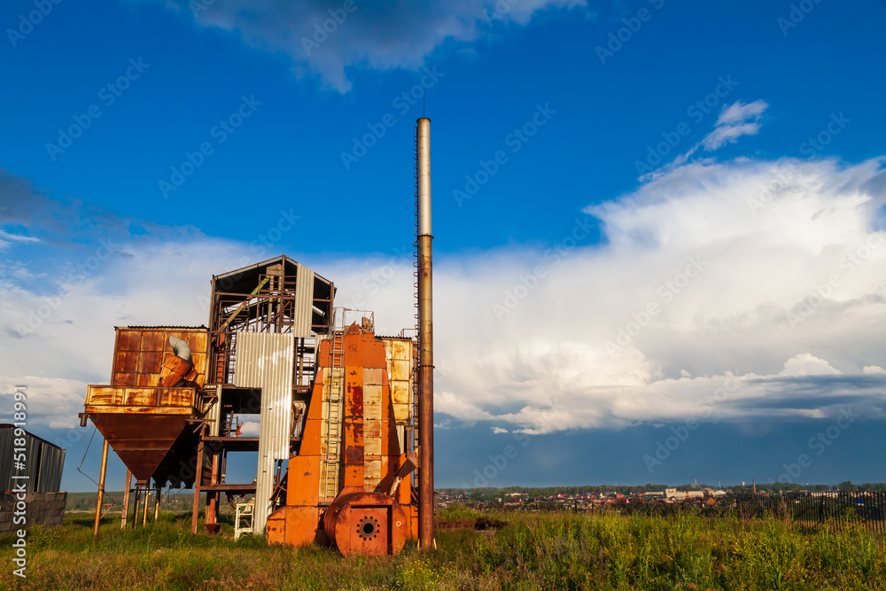 Old abandoned agricultural building with rusty iron walls. Soviet and Russian rural