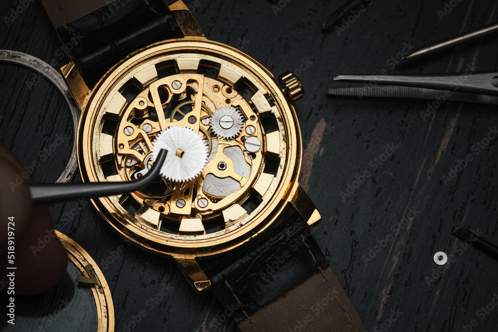 Obraz premium tweezers and disassembled mechanical watches