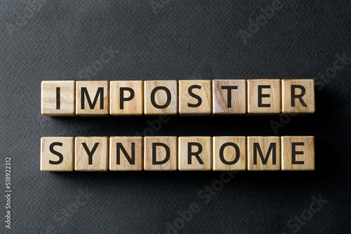 Impostor syndrome - phrase from wooden blocks with letters, psychological pattern inadequate incompetent Impostor syndrome concept, gray background