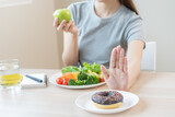 Diet, Dieting asian young woman or girl use hand push out, deny sweet donut and choose green salad vegetables, eat food for good healthy, health when hungry. Close up female weight loss person.