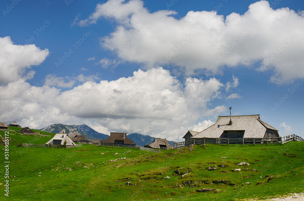 Velika Planina or Big Pasture Plateau in the Kamnik Alps, Slovenia. Mountain cottage hut or house on green hill. Alpine meadow landscape. Eco farming