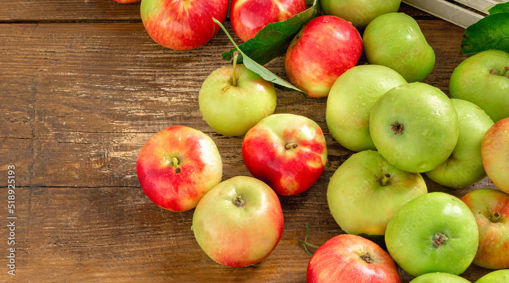 Harvest fresh various red and green apples on wooden background top view with copy space