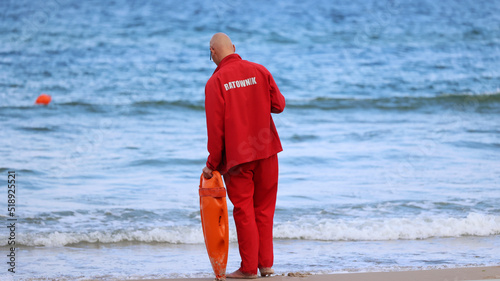 Ratownik na plaży podczas patrolowania brzegu wody. 