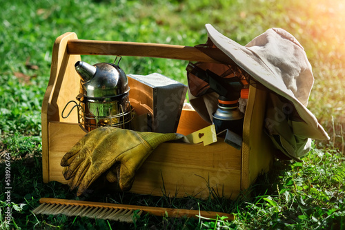 A tool of the beekeeper. Everything for a beekeeper to work with bees. Smoker, a chisel, a box, beekeeper suit for protection from the bees. Beekeeping equipment. Photo on the topic of beekeeping. photo