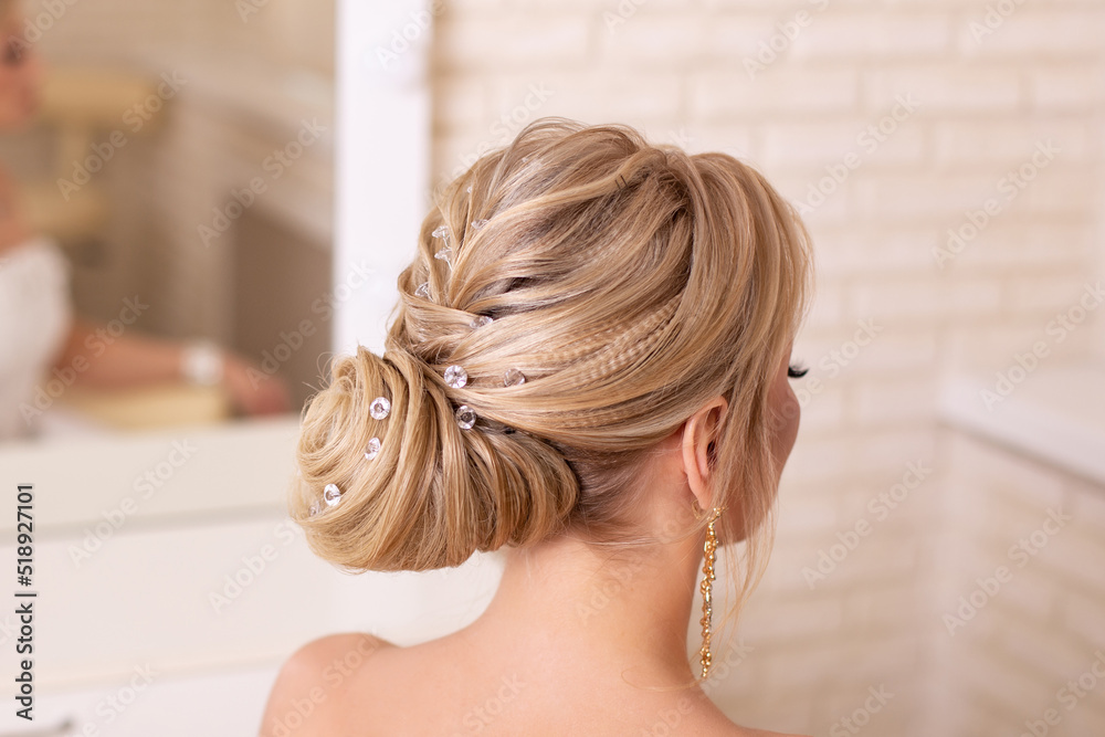 Naklejka premium Young beautiful bride with blonde wedding hairstyle and makeup in hairdressing salon 