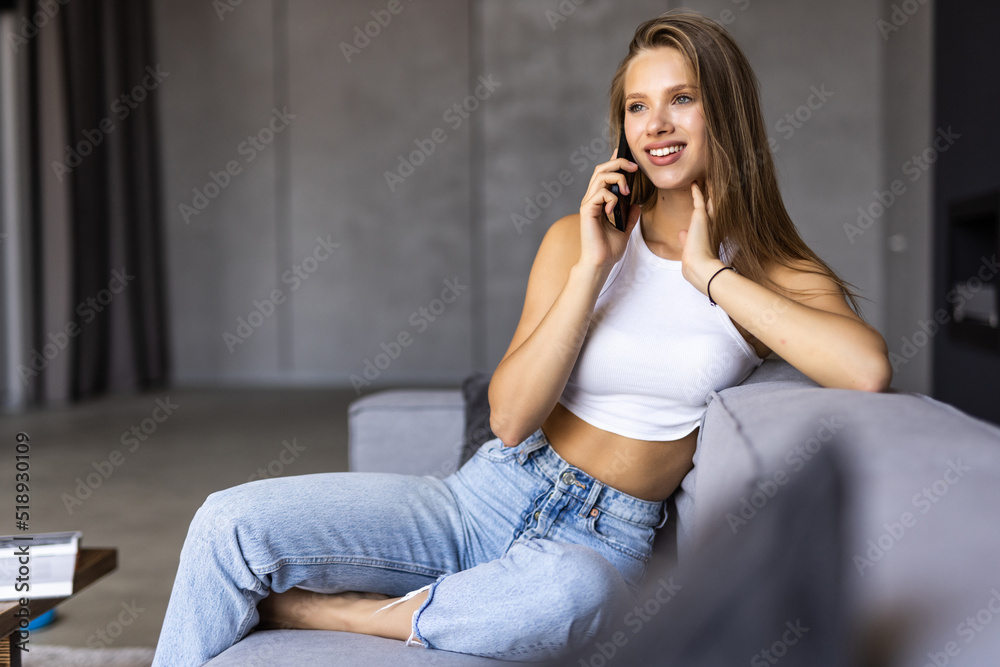 Pretty young woman using white mobile phone at home Pretty young woman using white mobile phone at home