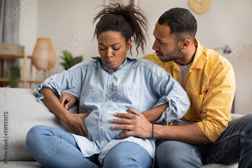Canvas Print Pregnant African Woman Having Labor Pains, Husband Hugging Her Indoors