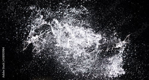 Water splash in air drop over black background, studio lighting high speed