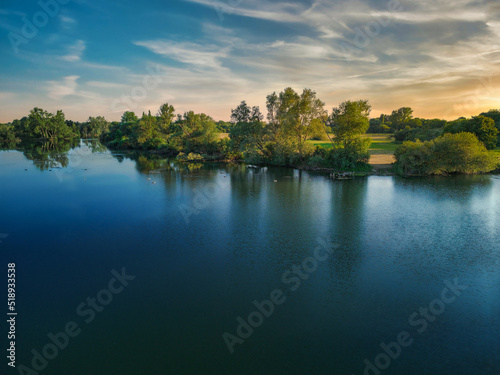 Fototapeta Naklejka Na Ścianę i Meble -  Calm water lake that looks like a mirror at sunset