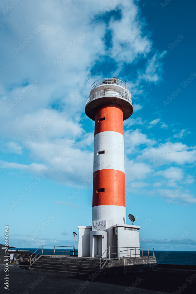 White and red lighthouse on a sunny day with clouds White and red lighthouse on a sunny day with clouds