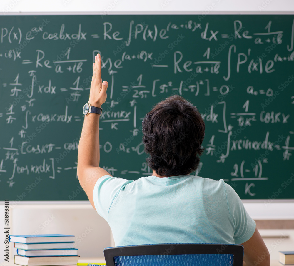Young male student mathematician in front of chalkboard Young male student mathematician in front of chalkboard