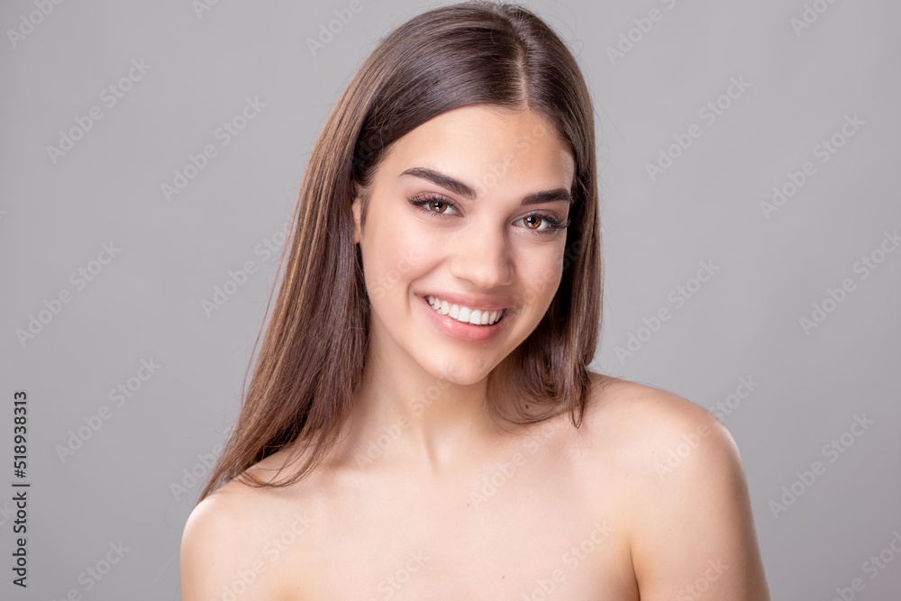Beautiful young woman with perfect skin and open smile. Portrait of beauty model with natural nude make up and touching her face. Spa, skincare and wellness. Close up, copyspace. Stock photo Beautiful young woman with perfect skin and open smile. Portrait of beauty model with natural nude make up and touching her face. Spa, skincare and wellness. Close up, copyspace. Stock photo