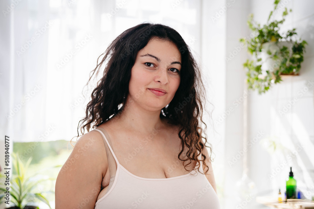 Portrait of overweight woman in pink underwear in light bathroom. Confident young woman feeling harmonous and calm in her body. Wellness Portrait of overweight woman in pink underwear in light bathroom. Confident young woman feeling harmonous and calm in her body. Wellness