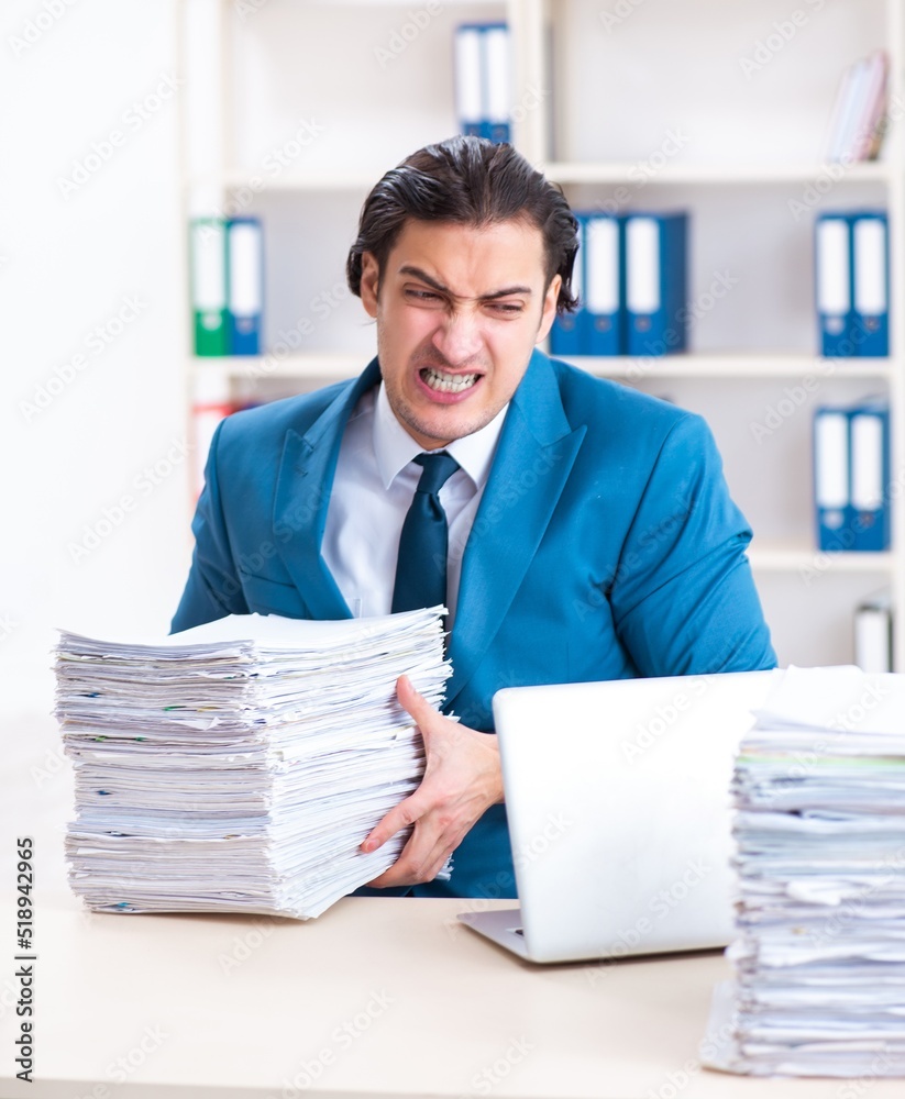 Young male employee unhappy with excessive work Young male employee unhappy with excessive work