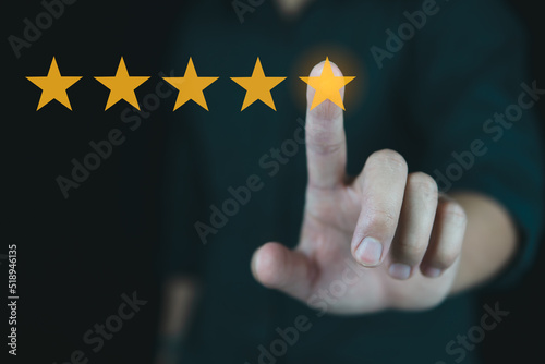 Customer review good rating concept hand pressing five star on visual screen and positive customer feedback testimonial.