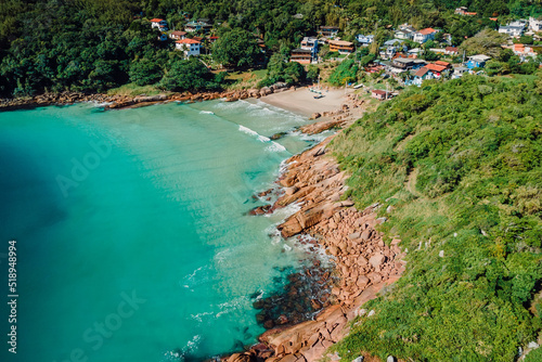 Beach, rocky coastline and transparent ocean in Brazil. Drone view of tropical beach in Florianopolis