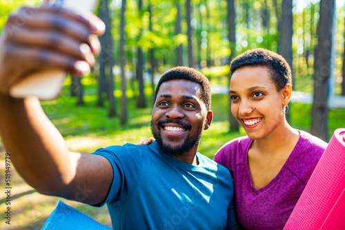 latin american couple ready to yoga time outdoors pink and blue look taking self portrait on modern smartphone