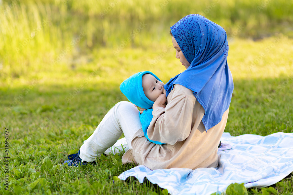 breast feeding concept. young islamic woman hugging newborn baby boy in