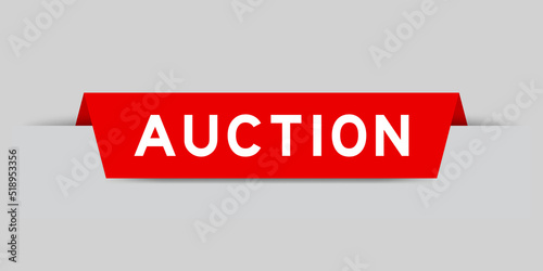 Red color inserted label with word auction on gray background