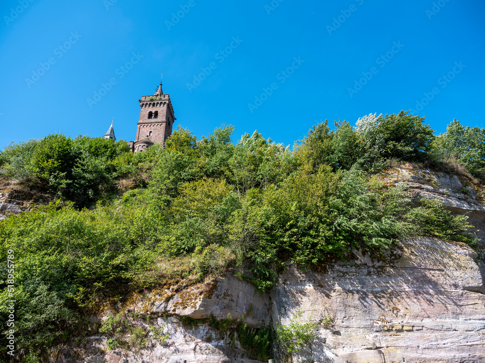 church tower under blue sky on rock of dabo in french vosges mountains