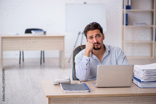 Young male employee and too much work in the office