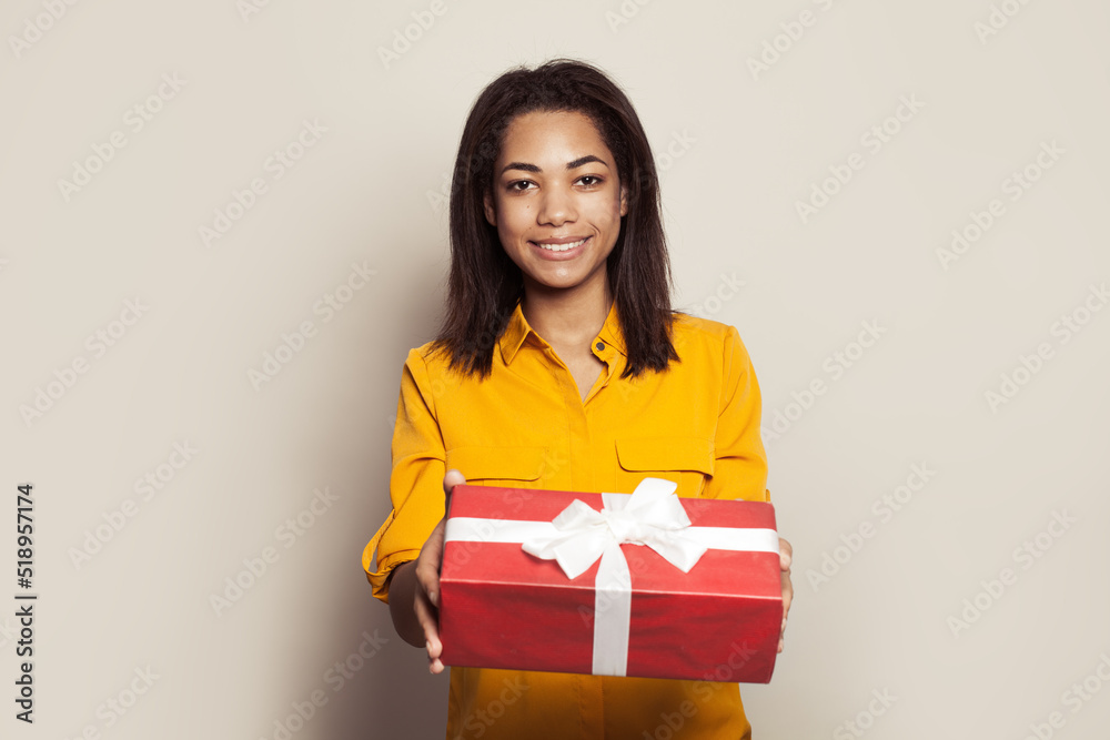 Happy excited african american young woman with gift box on white background Happy excited african american young woman with gift box on white background