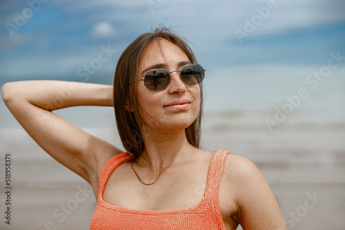 Portrait of beautiful woman in swimsuit standing beach on the background of ocean © Kostiantyn